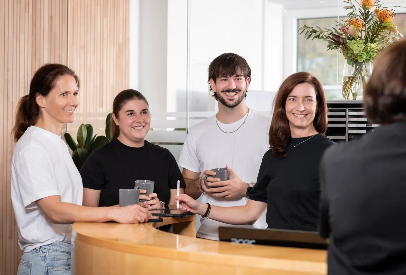 Kolleg:innen lachen zusammen in der Kaffeeküche des Therapiehauses